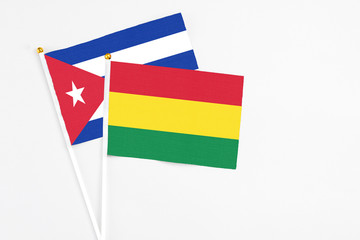 Bolivia and Cuba stick flags on white background. High quality fabric, miniature national flag. Peaceful global concept.White floor for copy space.
