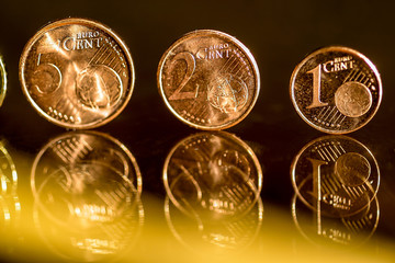 Euro coins on a glass table.