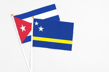 Curacao and Cuba stick flags on white background. High quality fabric, miniature national flag. Peaceful global concept.White floor for copy space.