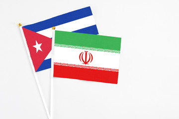 Iran and Cuba stick flags on white background. High quality fabric, miniature national flag. Peaceful global concept.White floor for copy space.