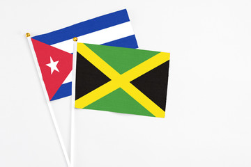 Jamaica and Cuba stick flags on white background. High quality fabric, miniature national flag. Peaceful global concept.White floor for copy space.