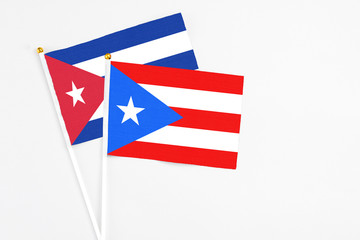 Puerto Rico and Cuba stick flags on white background. High quality fabric, miniature national flag. Peaceful global concept.White floor for copy space.