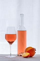 Rose wine in bottle, wineglass and persimmon fruit. Still life