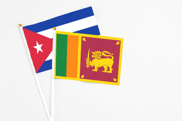 Sri Lanka and Cuba stick flags on white background. High quality fabric, miniature national flag. Peaceful global concept.White floor for copy space.