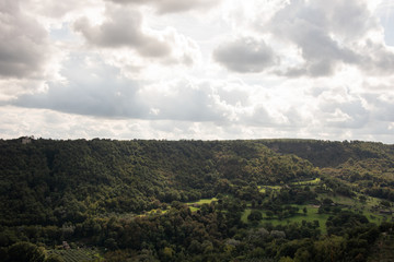 Green Tuscany landscape under cloudy sky near Bagnoregio, Viterbo, Italy. 