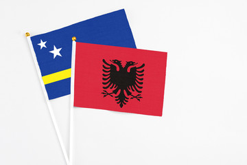 Albania and Curacao stick flags on white background. High quality fabric, miniature national flag. Peaceful global concept.White floor for copy space.