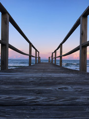 Boardwalk walkway to ocean at sunset