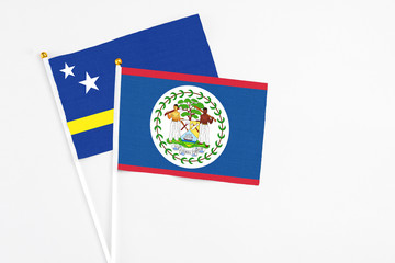 Belize and Curacao stick flags on white background. High quality fabric, miniature national flag. Peaceful global concept.White floor for copy space.
