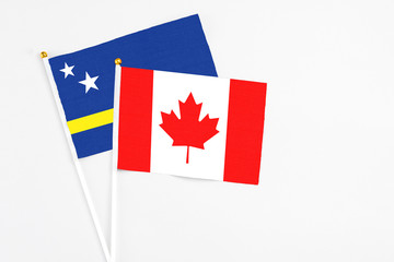 Canada and Curacao stick flags on white background. High quality fabric, miniature national flag. Peaceful global concept.White floor for copy space.