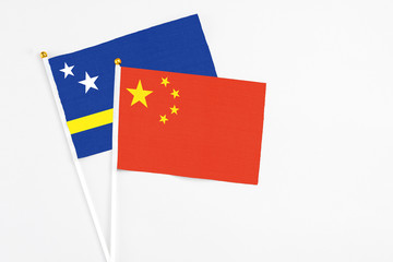 China and Curacao stick flags on white background. High quality fabric, miniature national flag. Peaceful global concept.White floor for copy space.