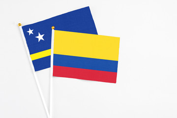 Colombia and Curacao stick flags on white background. High quality fabric, miniature national flag. Peaceful global concept.White floor for copy space.