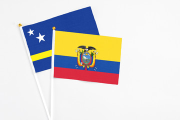 Ecuador and Curacao stick flags on white background. High quality fabric, miniature national flag. Peaceful global concept.White floor for copy space.