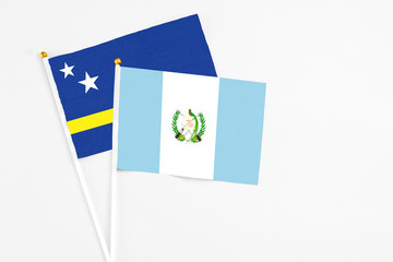 Guatemala and Curacao stick flags on white background. High quality fabric, miniature national flag. Peaceful global concept.White floor for copy space.