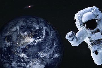 Obraz na płótnie Canvas Astronaut near night Earth planet of solar system Closeup. Outer space journy. Science fiction. Elements of the image were furnished by NASA