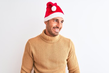 Young handsome man wearing christmas and turtleneck sweater over isolated background looking away to side with smile on face, natural expression. Laughing confident.