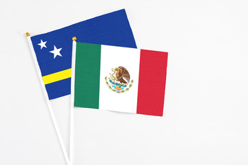 Mexico and Curacao stick flags on white background. High quality fabric, miniature national flag. Peaceful global concept.White floor for copy space.