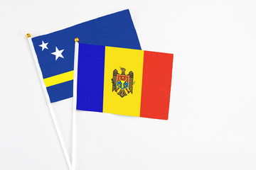 Moldova and Curacao stick flags on white background. High quality fabric, miniature national flag. Peaceful global concept.White floor for copy space.