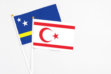 Northern Cyprus and Curacao stick flags on white background. High quality fabric, miniature national flag. Peaceful global concept.White floor for copy space.
