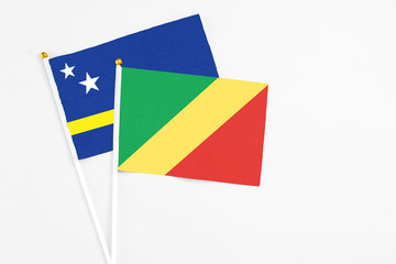 Republic Of The Congo and Curacao stick flags on white background. High quality fabric, miniature national flag. Peaceful global concept.White floor for copy space.