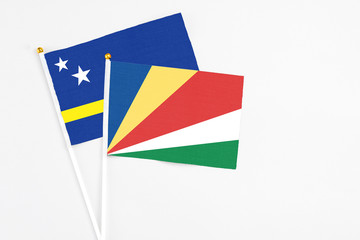 Seychelles and Curacao stick flags on white background. High quality fabric, miniature national flag. Peaceful global concept.White floor for copy space.