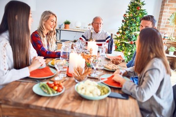 Beautiful family meeting smiling happy and confident. Eating roasted turkey celebrating Christmas at home