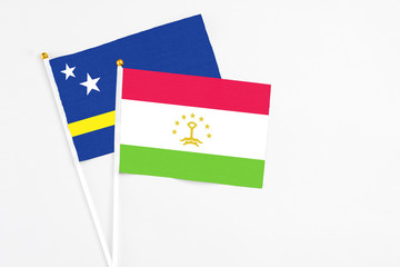 Tajikistan and Curacao stick flags on white background. High quality fabric, miniature national flag. Peaceful global concept.White floor for copy space.