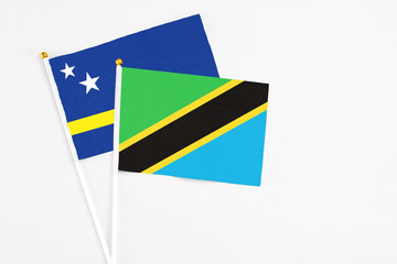 Tanzania and Curacao stick flags on white background. High quality fabric, miniature national flag. Peaceful global concept.White floor for copy space.
