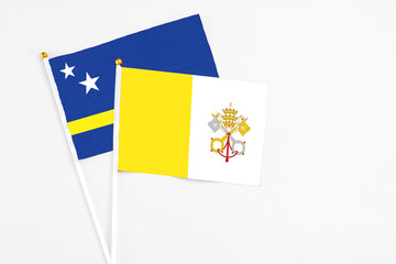 Vatican City and Curacao stick flags on white background. High quality fabric, miniature national flag. Peaceful global concept.White floor for copy space.