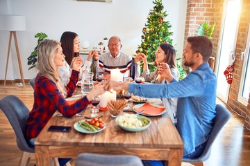 Beautiful family meeting smiling happy and confident. Praying taking hands before eating roasted turkey celebrating Christmas at home