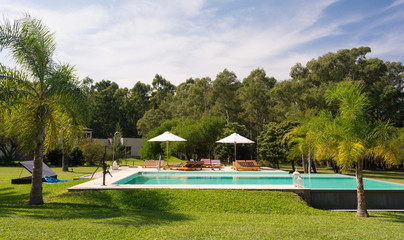Beautiful view of a swimming pool in a sunny day. Gardens of a typical countryside lodging...