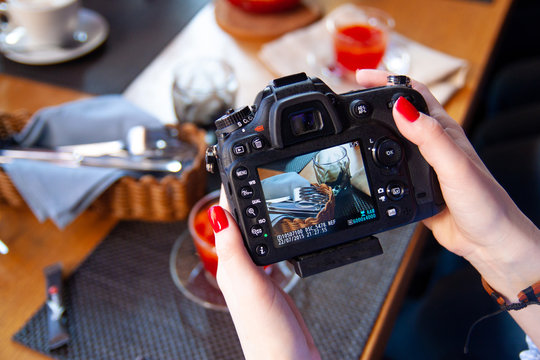 Food photography, DSLR camera in woman hands shooting food in restaurant