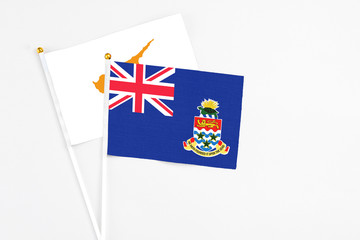 Cayman Islands and Cyprus stick flags on white background. High quality fabric, miniature national flag. Peaceful global concept.White floor for copy space.