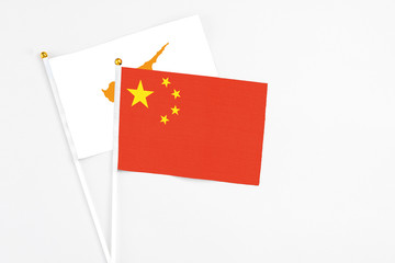China and Cyprus stick flags on white background. High quality fabric, miniature national flag. Peaceful global concept.White floor for copy space.