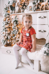 Beautiful litttle girl with christmas tree in the background