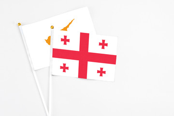 Georgia and Cyprus stick flags on white background. High quality fabric, miniature national flag. Peaceful global concept.White floor for copy space.