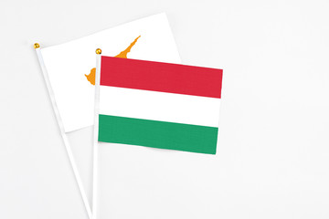 Hungary and Cyprus stick flags on white background. High quality fabric, miniature national flag. Peaceful global concept.White floor for copy space.