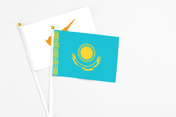 Kazakhstan and Cyprus stick flags on white background. High quality fabric, miniature national flag. Peaceful global concept.White floor for copy space.