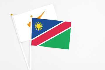 Namibia and Cyprus stick flags on white background. High quality fabric, miniature national flag. Peaceful global concept.White floor for copy space.