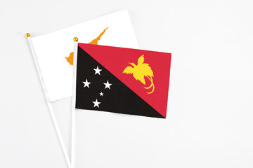 Papua New Guinea and Cyprus stick flags on white background. High quality fabric, miniature national flag. Peaceful global concept.White floor for copy space.
