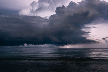 flash of lightning in night sky over sea