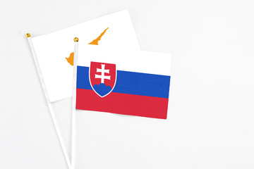 Slovakia and Cyprus stick flags on white background. High quality fabric, miniature national flag. Peaceful global concept.White floor for copy space.