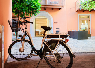 Fototapeta na wymiar Old street with bicycle parked. Vintage style and bike public vehicle tourism. Summer background. Lifestyle design. Side view. Travel background. Traditional european sport. Spring vacation.