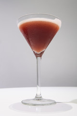 Sangria cocktail in clear cocktail glass on white table gray background. Drink concept.
