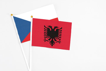 Fototapeta premium Albania and Cyprus stick flags on white background. High quality fabric, miniature national flag. Peaceful global concept.White floor for copy space.