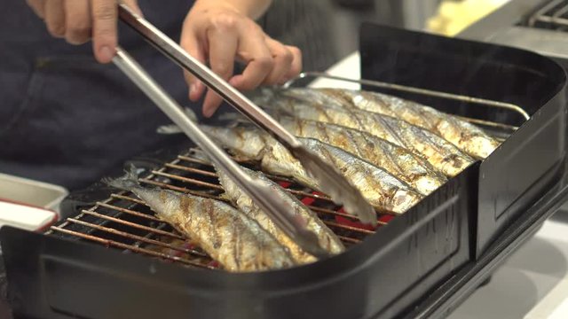 Chef cooking grill mackerel or saba fish with shoyu sauce in japanese street food market event