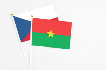 Naklejka premium Burkina Faso and Cyprus stick flags on white background. High quality fabric, miniature national flag. Peaceful global concept.White floor for copy space.