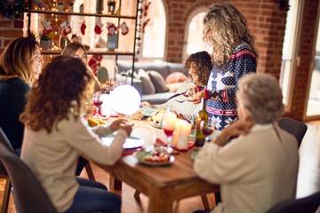Beautiful group of women smiling happy and confident. Carving roasted turkey celebrating christmas at home