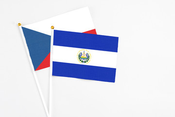 El Salvador and Cyprus stick flags on white background. High quality fabric, miniature national flag. Peaceful global concept.White floor for copy space.