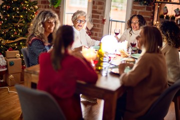 Beautiful group of women smiling happy and confident. Eating roasted turkey celebrating christmas at home
