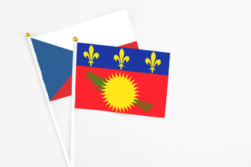 Guadeloupe and Cyprus stick flags on white background. High quality fabric, miniature national flag. Peaceful global concept.White floor for copy space.